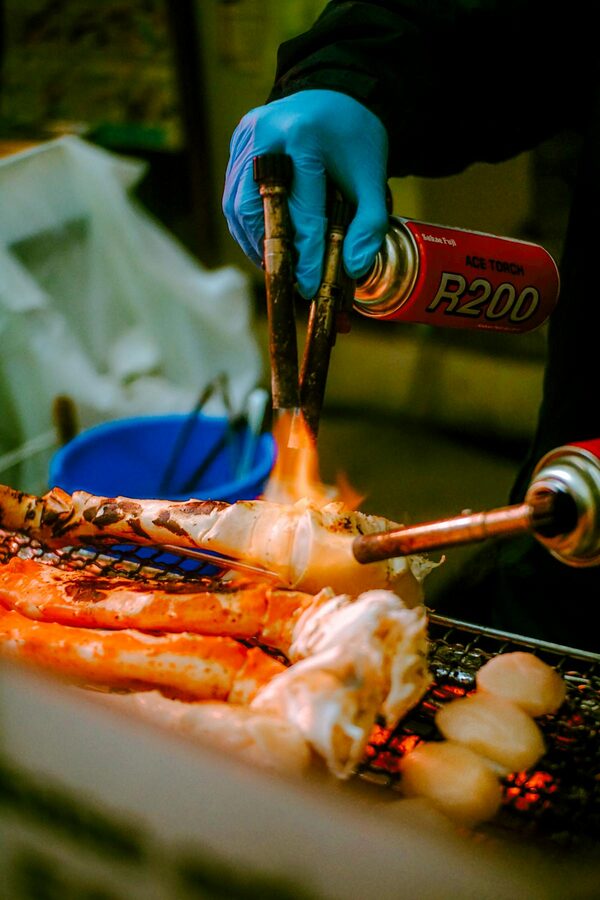 Street vendor grilling fresh seafood at an Osaka market stall