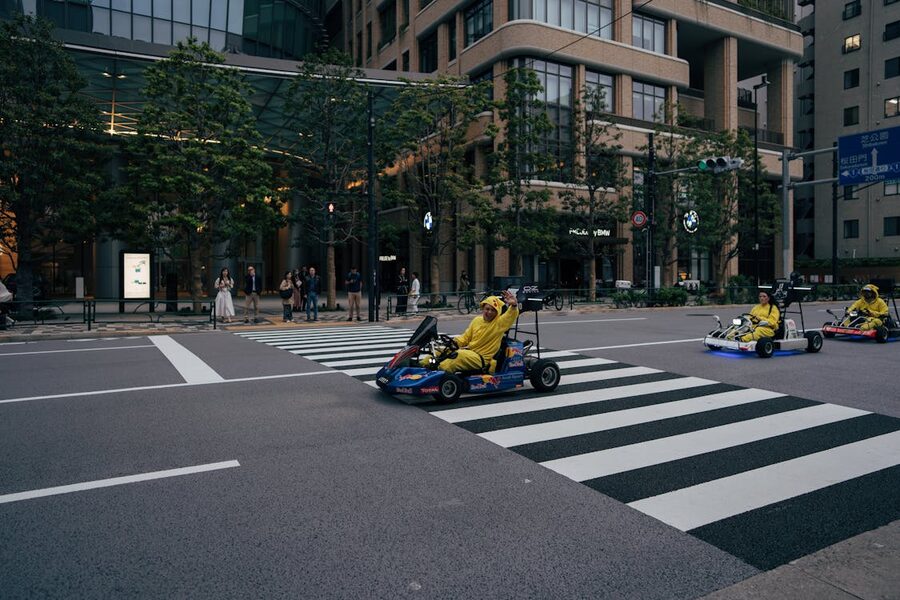 People in colorful costumes driving go-karts through Tokyo streets