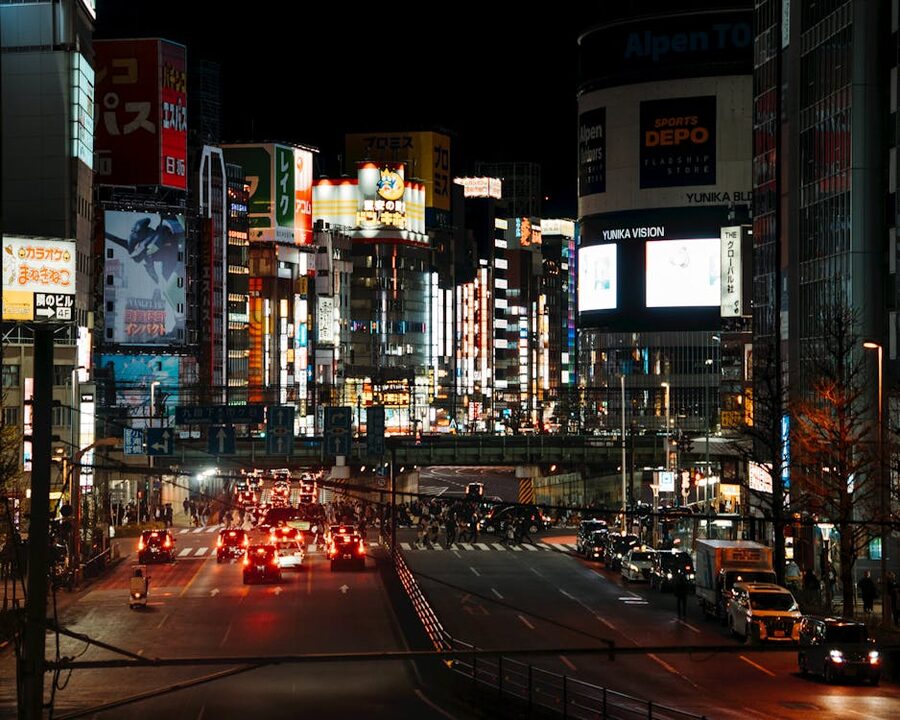 Bright neon-lit scene in Shinjuku Tokyo at night with traffic