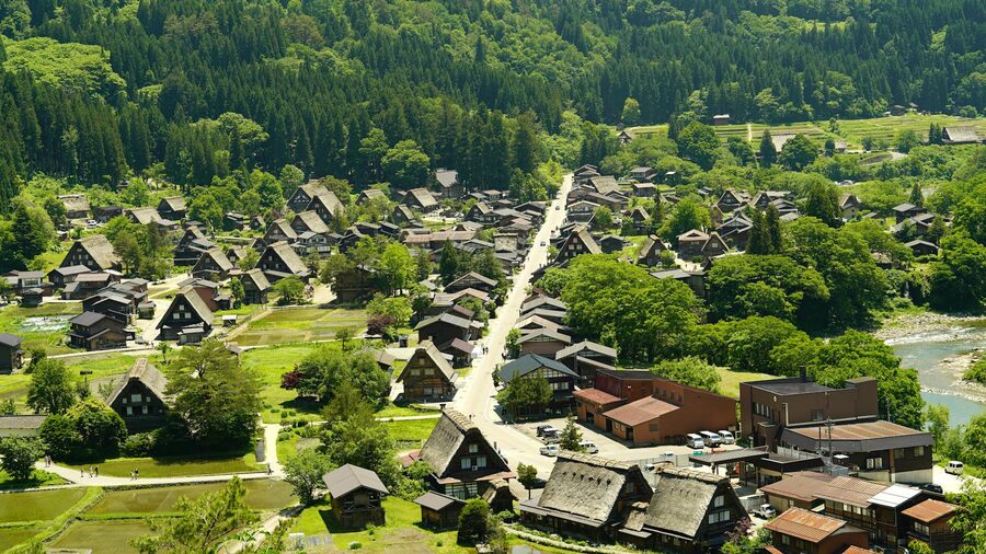 Stunning aerial view of Shirakawa-go showing traditional gassho-style houses surrounded by lush greenery