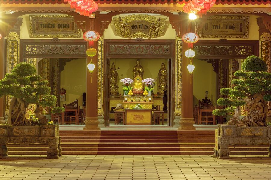Pagoda adorned with red lanterns and golden Buddha statues in Da Nang