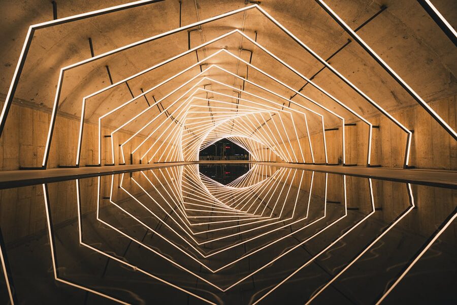 Illuminated geometric tunnel with LED lights reflecting on water surface