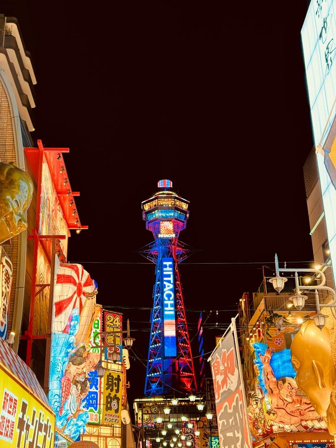 Night view of Tsutenkaku Tower in Osaka surrounded by neon signs