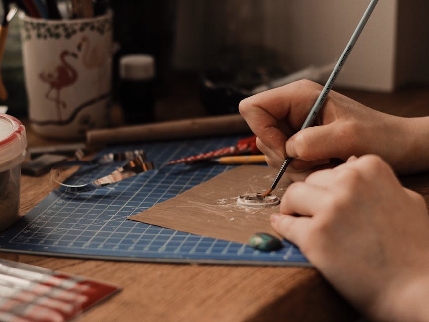 A close-up view of a person crafting jewelry using precision tools
