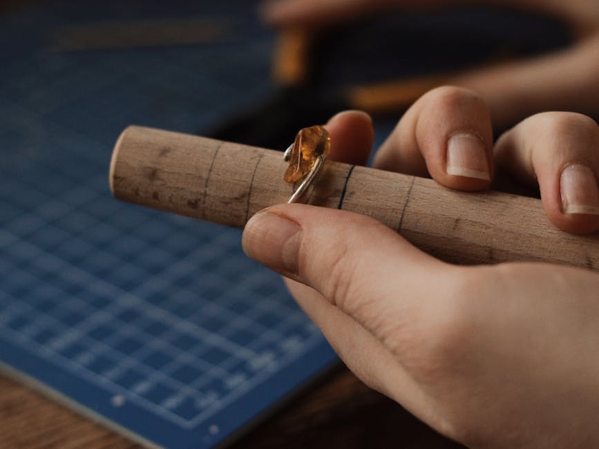 A jeweler crafting a gemstone ring on a mandrel