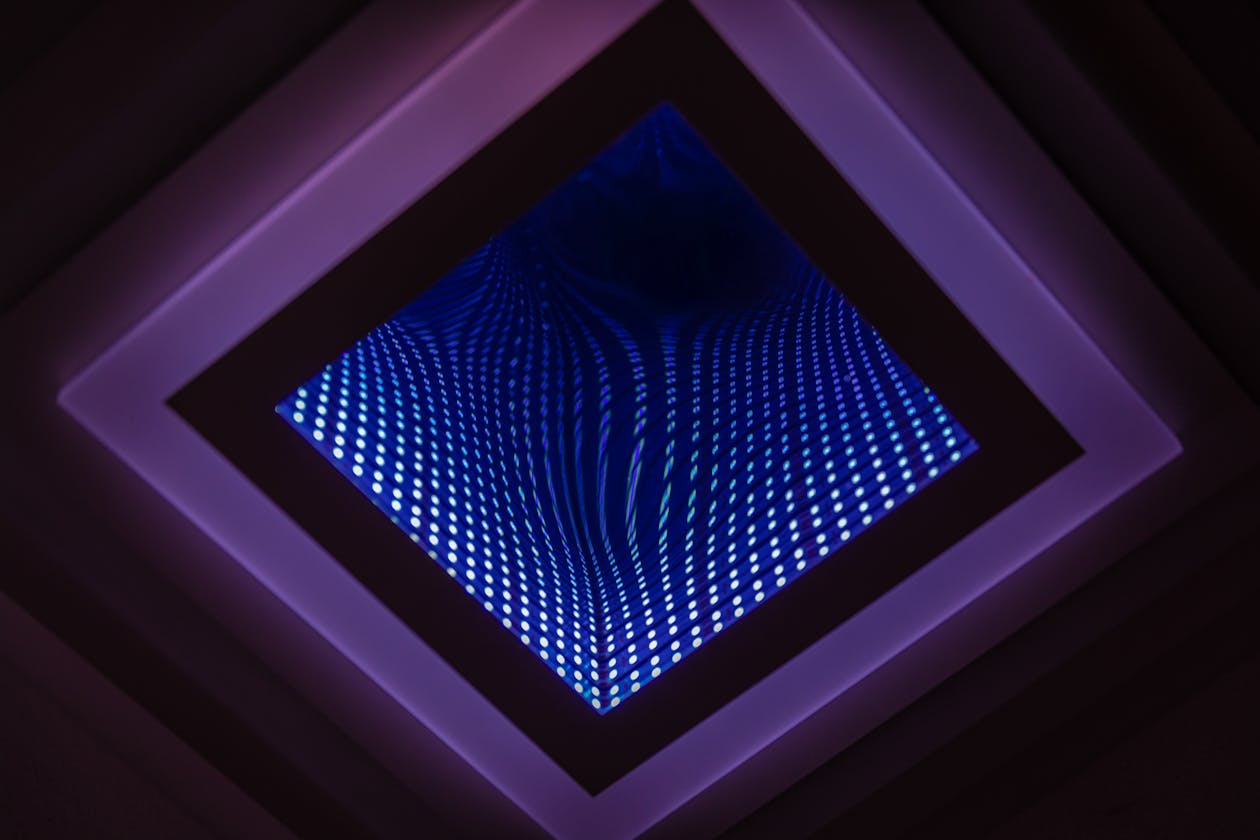 Abstract LED infinity mirror creating colorful repeating light patterns