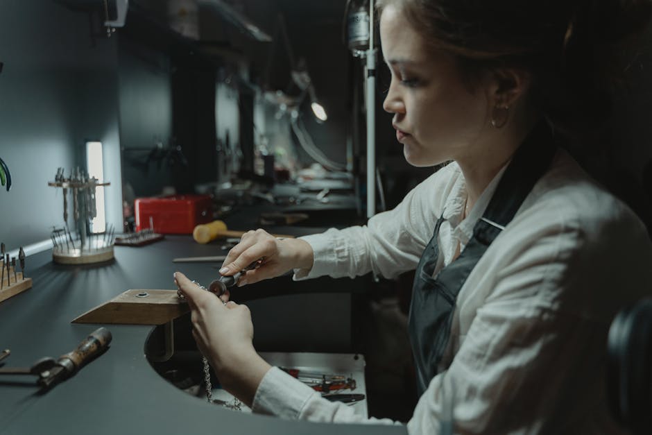 A skilled woman jeweler focusing on detailed craftsmanship