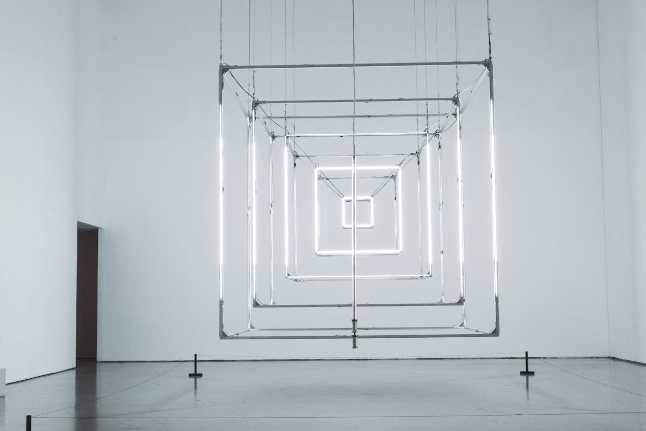 Geometric light cubes installation in a minimal dark gallery setting