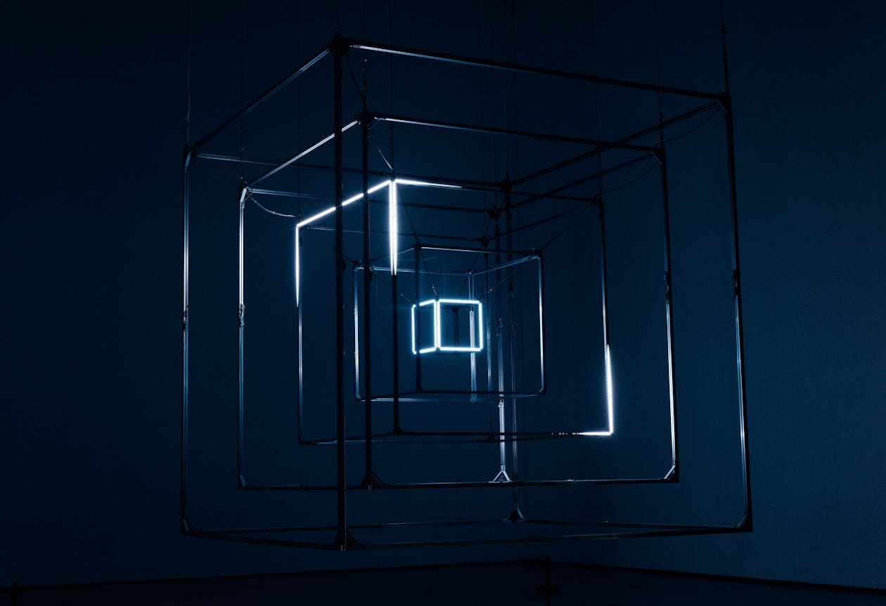 Captivating geometric light installation with neon-lit cubes against a dark background