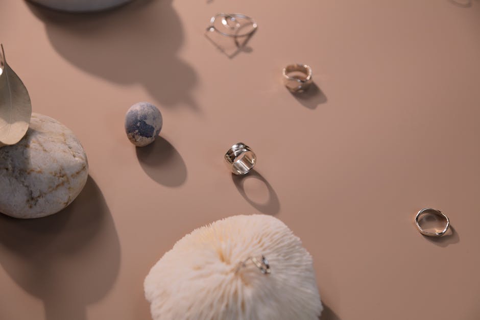 Minimalist arrangement of silver rings on a beige background
