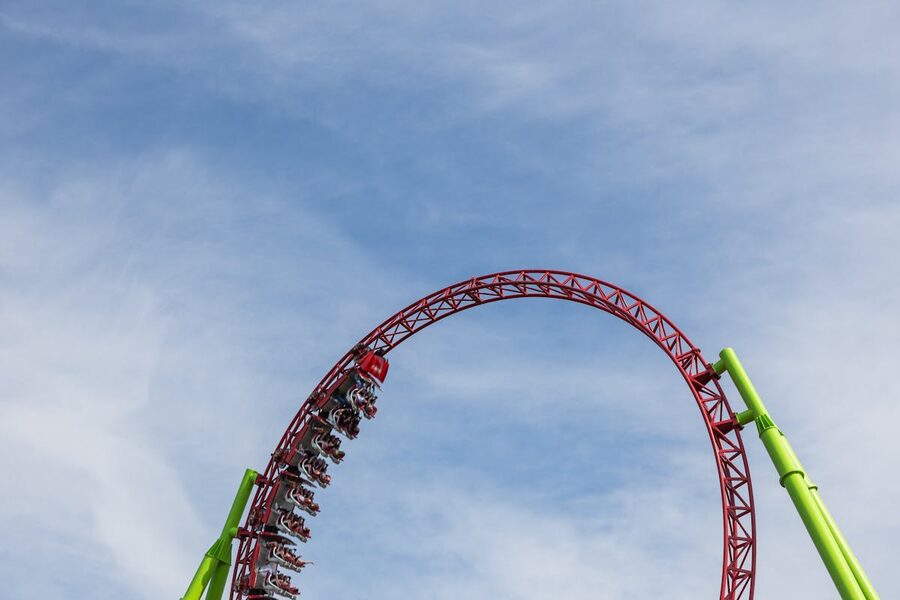 Roller coaster doing a loop against clear blue sky