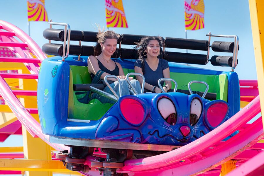 Two friends laughing and screaming on a roller coaster
