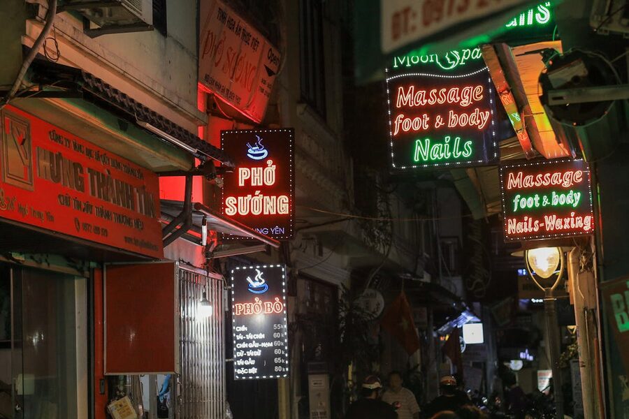 Colorful neon signs illuminating a street in Hanoi at night