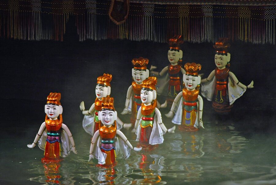 Traditional Vietnamese water puppets performing in a mist-filled scene