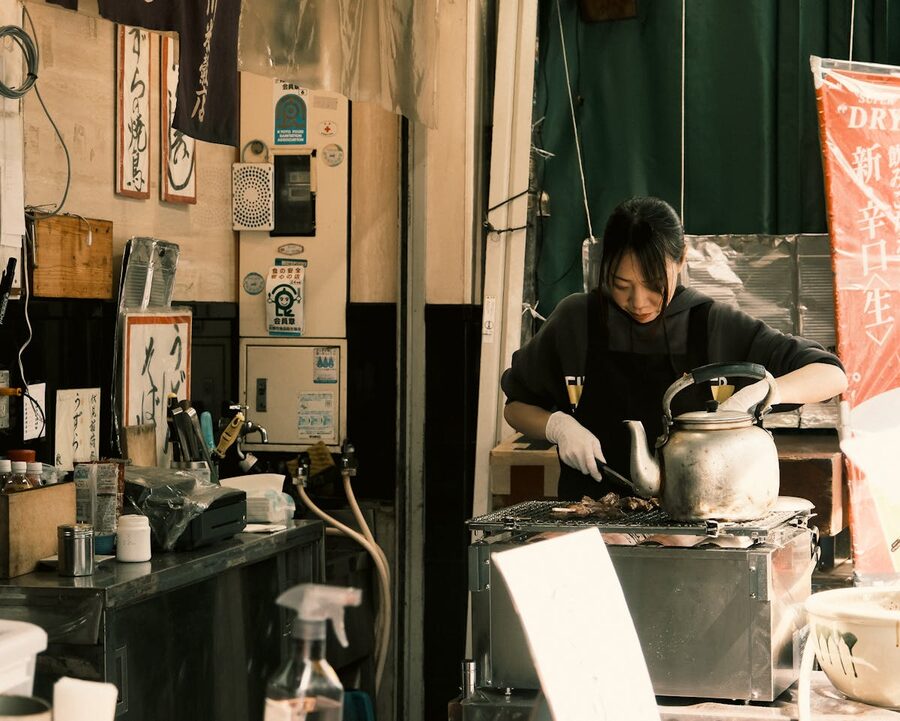 Street vendor preparing food at a stall in a Tokyo market