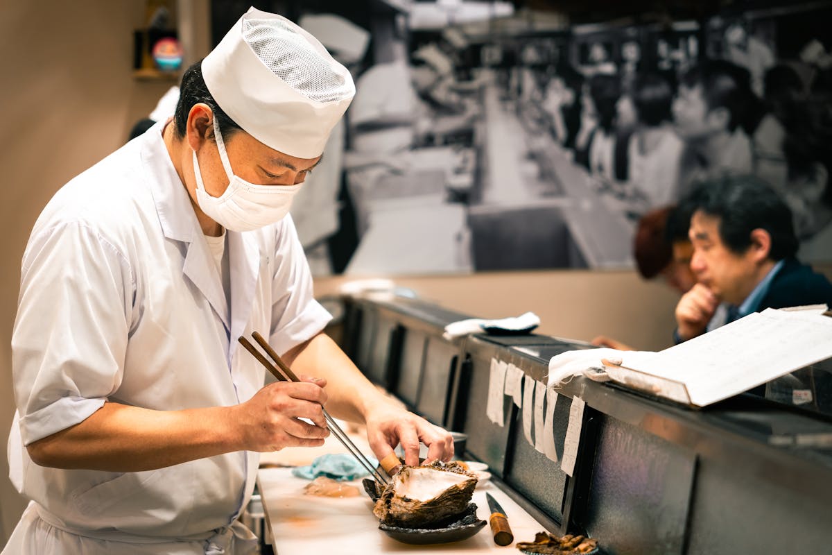 Sushi chef skillfully preparing fresh seafood at a restaurant in Tokyo