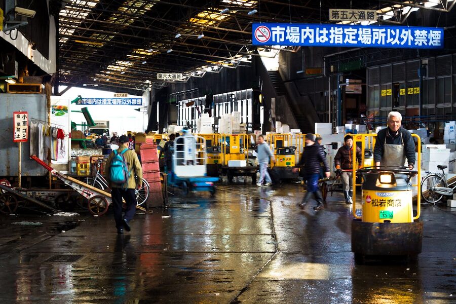 Wholesale fish market scene in Tokyo with carts and transport vehicles
