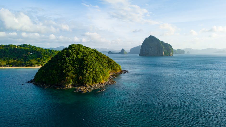 Aerial view of lush green tropical islands surrounded by turquoise sea in Palawan