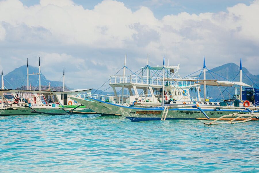 Traditional Filipino outrigger banca boat on turquoise water between two islands