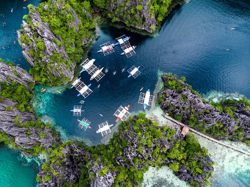 Aerial view of boats on turquoise water surrounded by limestone karst cliffs