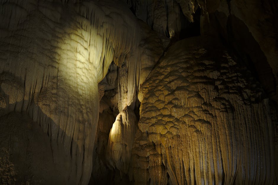 Dramatic limestone stalactites and stalagmites in a dark cave interior