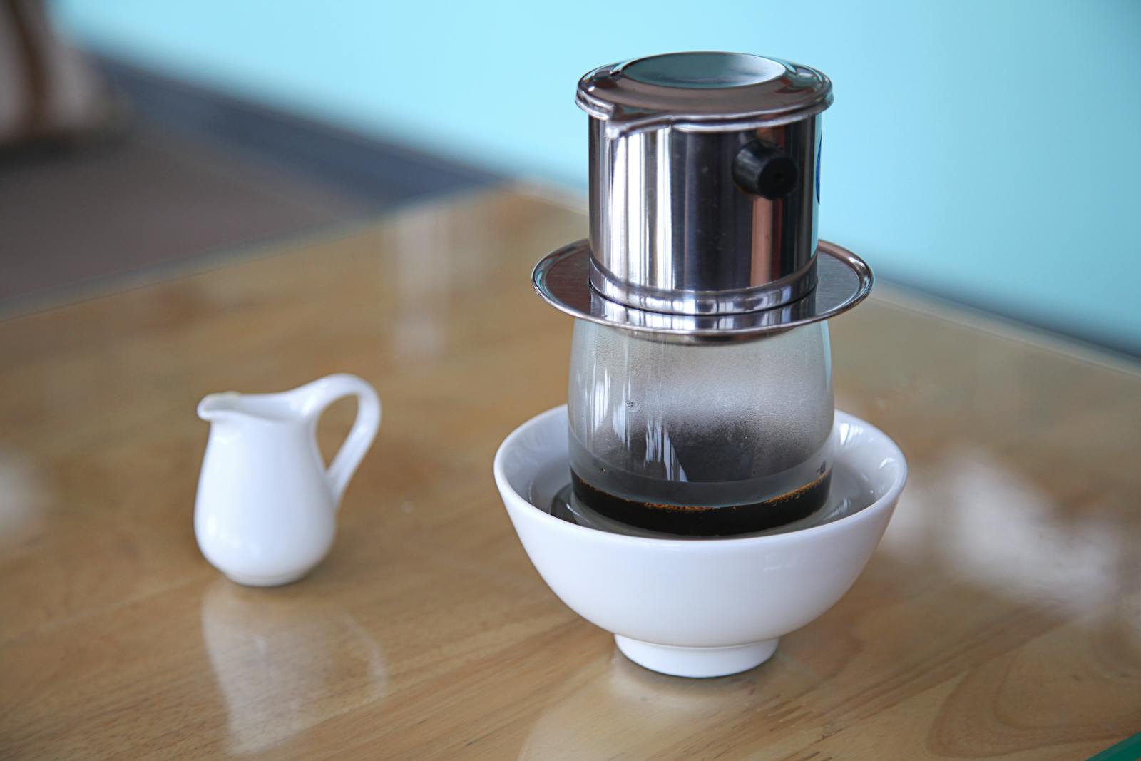 Traditional Vietnamese phin coffee filter dripping slowly into a clear glass