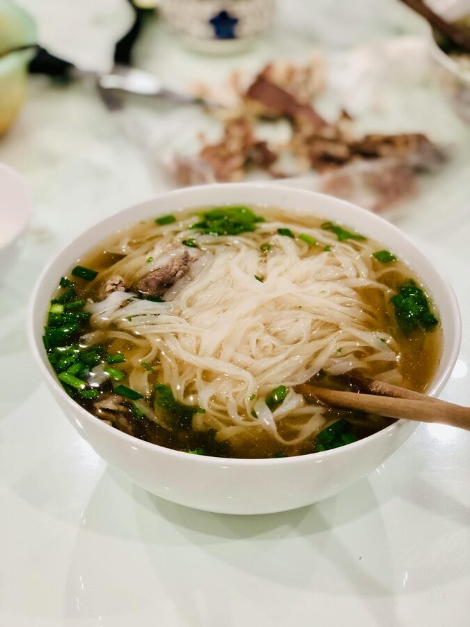 Vietnamese pho noodle soup with fresh herbs and lime