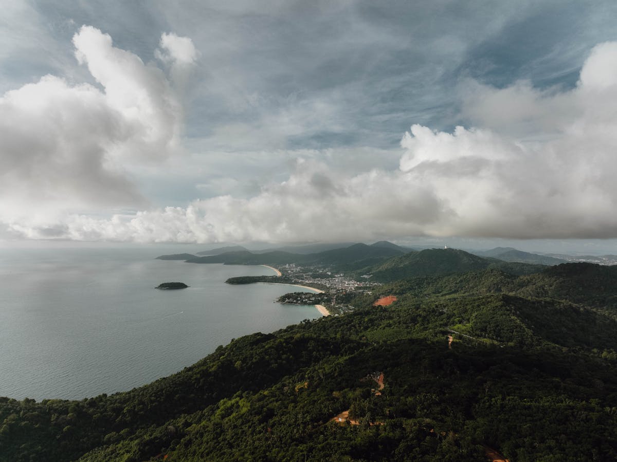 Aerial view of Phuket's hills and coastline under cloudy sky