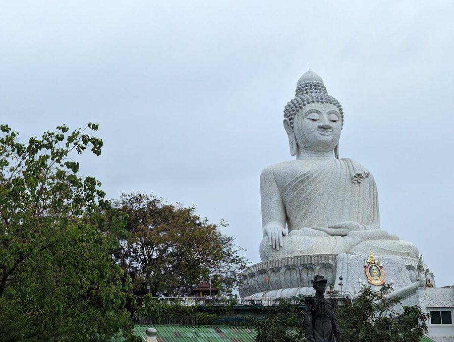 Big Buddha statue surrounded by lush green jungle in Phuket Thailand