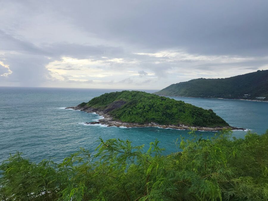 Green hills and turquoise waters at Promthep Cape in Phuket Thailand