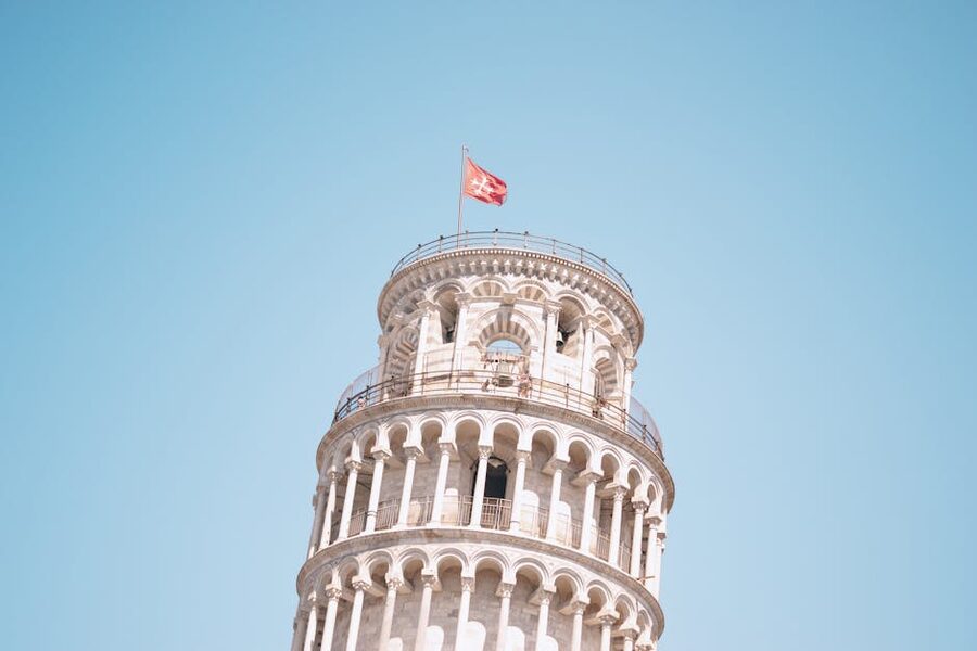 Marble detail of the Leaning Tower of Pisa against a blue sky