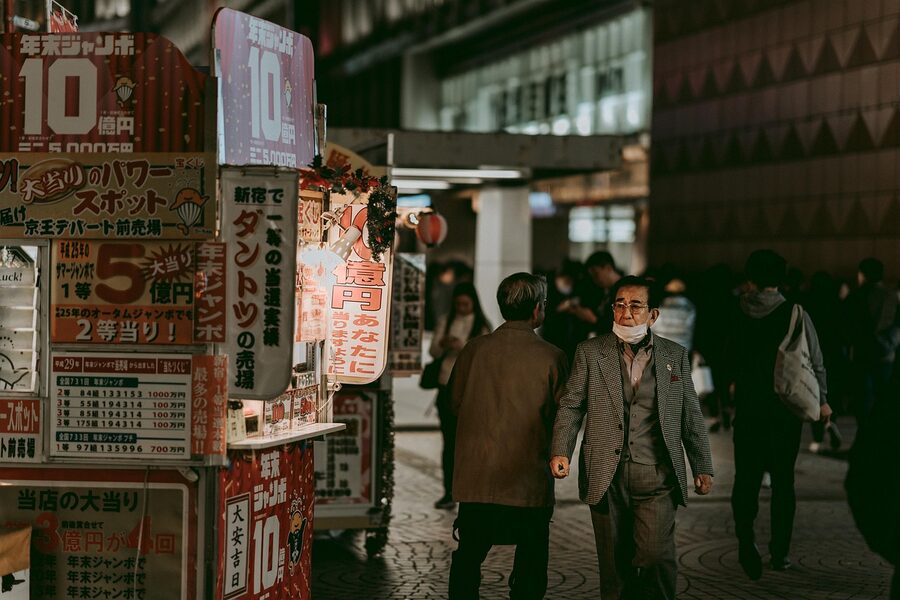 Busy Shinjuku street at night with pedestrians and neon signs
