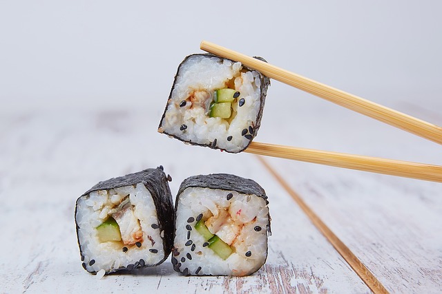 Close-up of sushi roll with chopsticks on a traditional Japanese plate