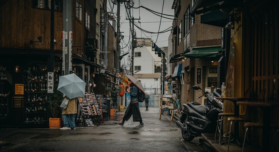 Woman walking through market streets in Tokyo Japan