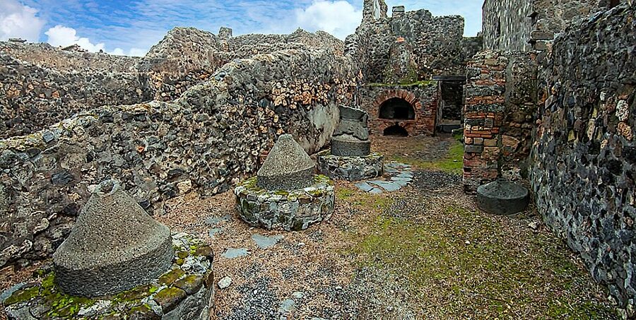 Pompeii bakery showing millstones and oven preserved in ash