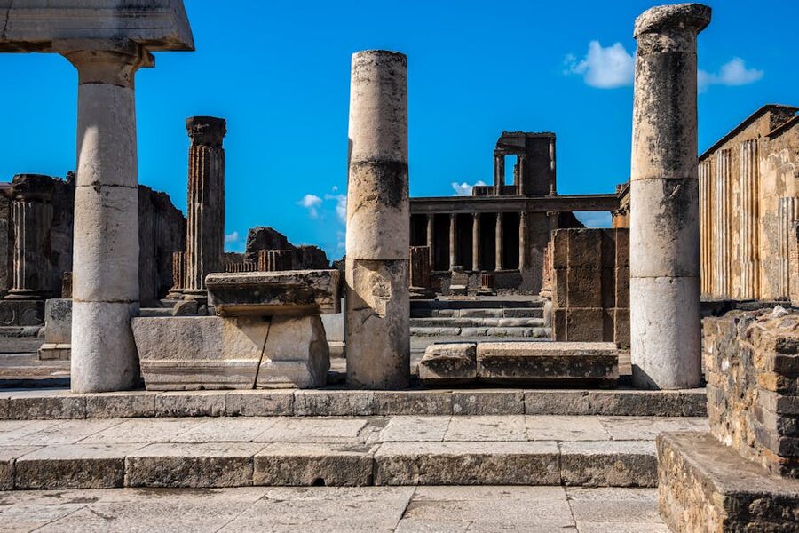 Preserved stone columns in Pompeii ruins under blue sky