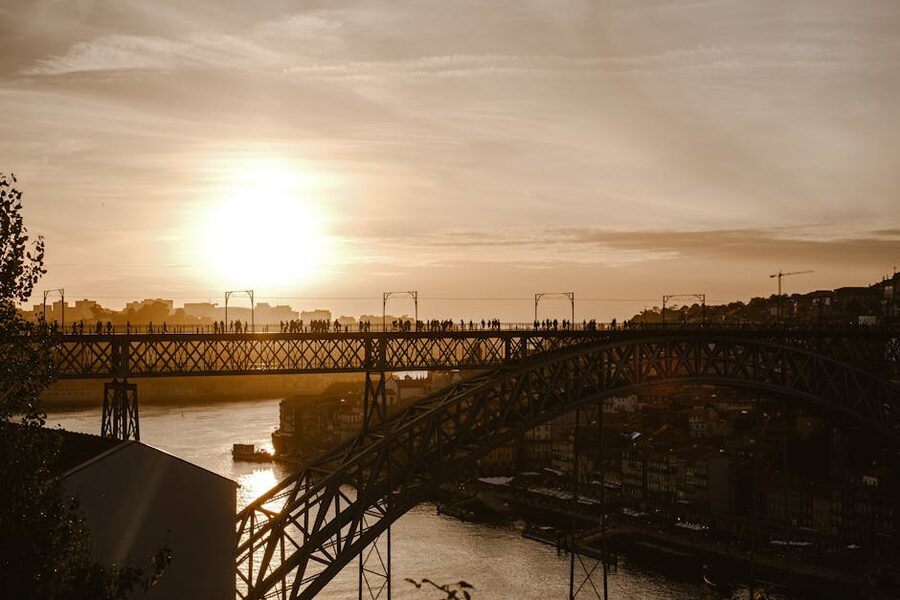 Sunset silhouette of walkers on Dom Luis I Bridge upper deck Porto