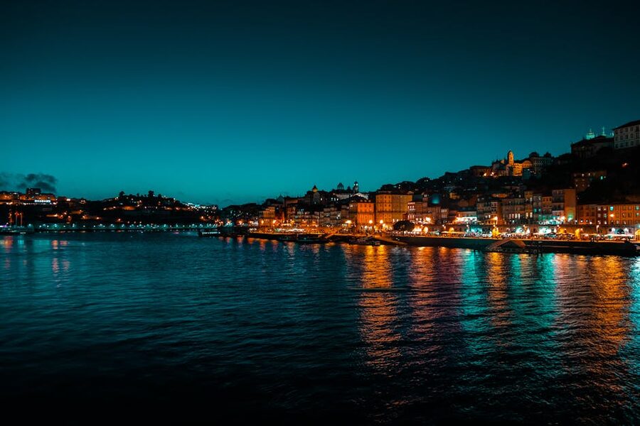 Porto waterfront illuminated at night across the Douro