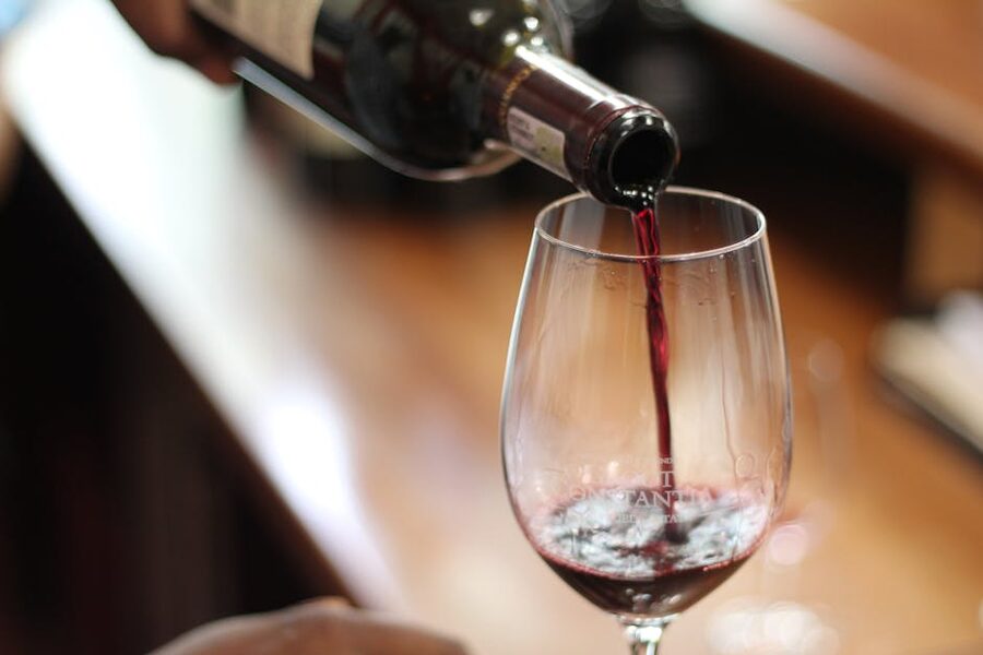 Red wine being poured into a tasting glass