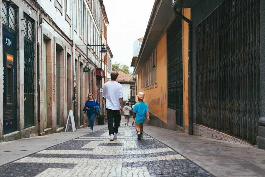 People walking narrow alley with colorful buildings in Porto