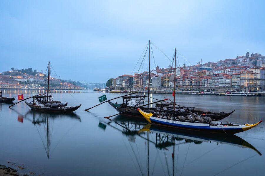 Traditional Rabelo boats reflected on the Douro at twilight in Porto