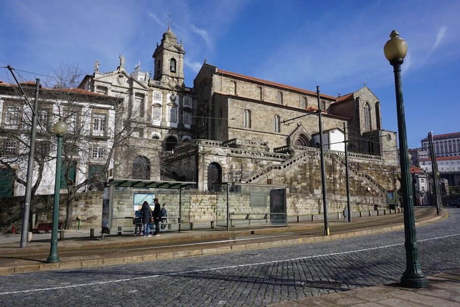 Porto street with church and tram lines under blue sky