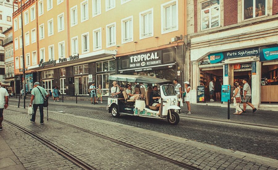 Porto street scene with a tuk-tuk and pedestrians