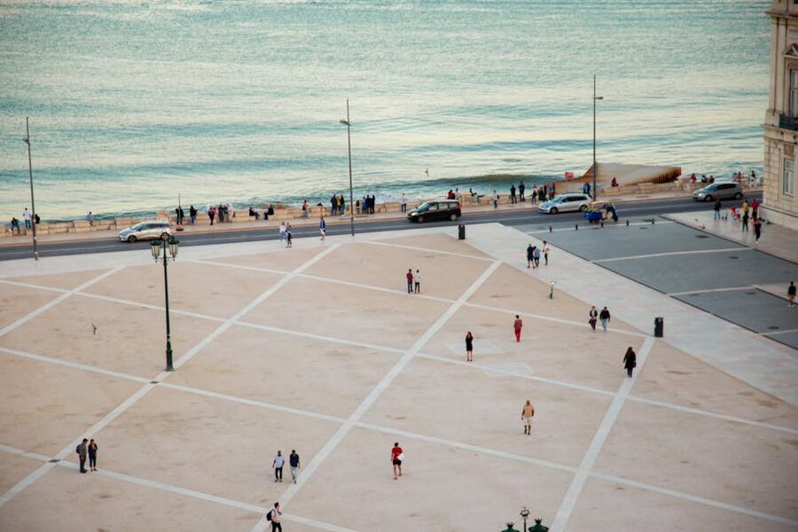 People walking on Praça do Comércio waterfront in Lisbon