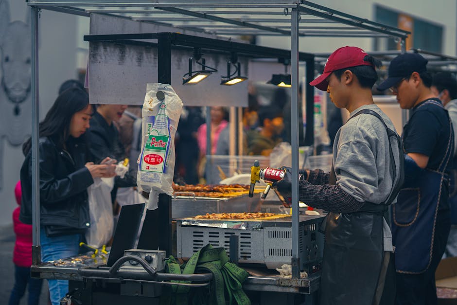 Women at a food stall serving customers at a Korean market