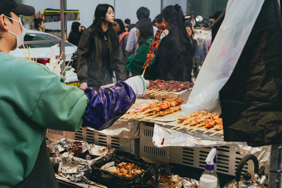 Vendors serving street food at a busy Seoul market stall