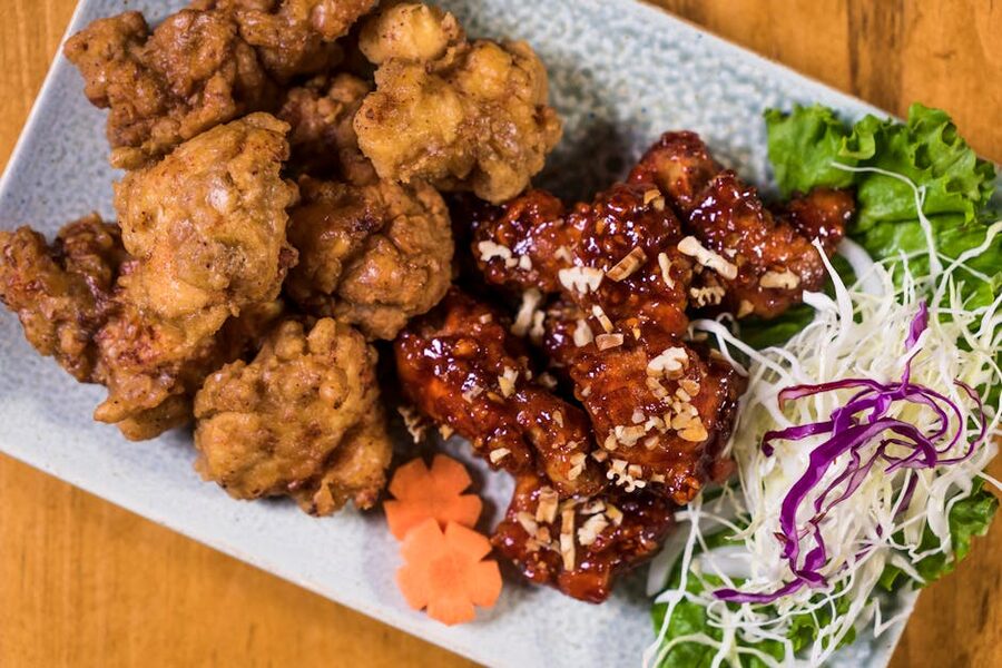 Plate of Korean fried chicken with sides on a ceramic dish