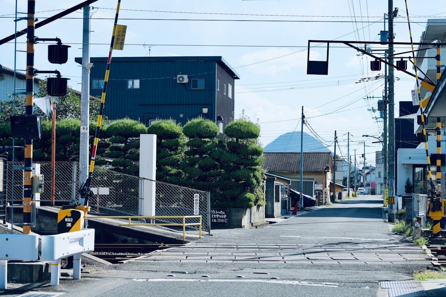 Quiet street scene of a Japanese railway crossing with a mountain view