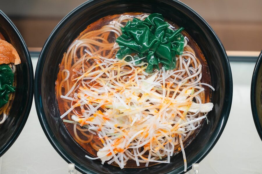 Top view of ramen bowl with noodles, spinach, and toppings in Tokyo