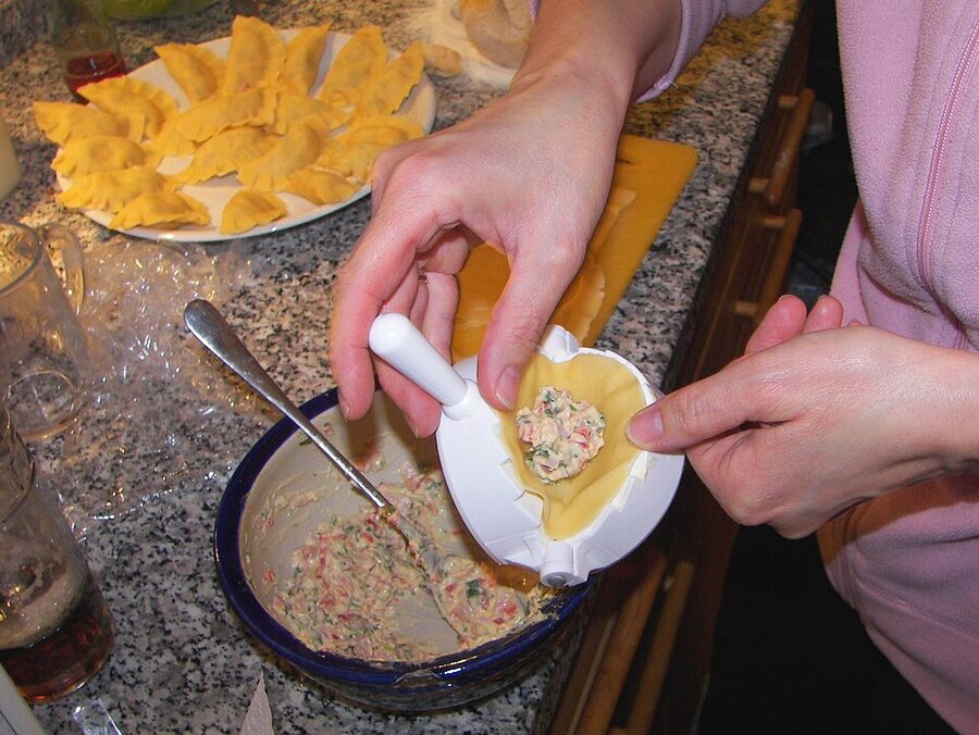 Filling fresh ravioli pockets with ricotta and spinach by hand